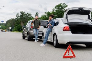 people on the phone by their cars